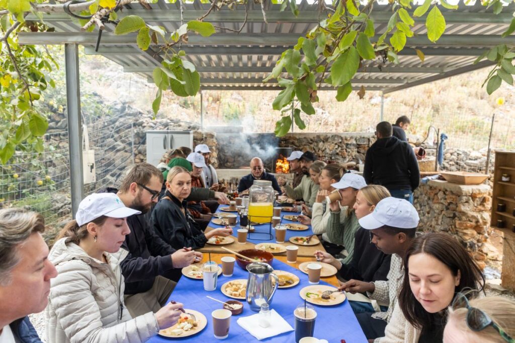 TP Team eating at a large table after their environmental action at Arevitis Farm in creta