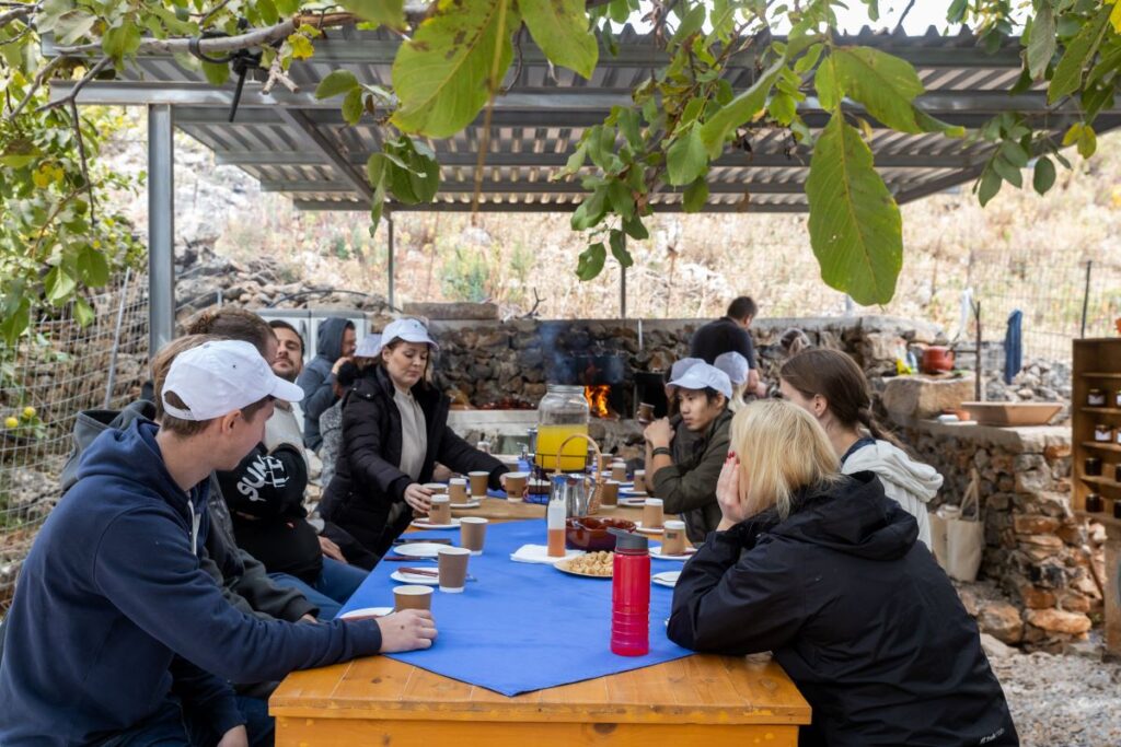 TP Team eating at a large table after their environmental action at Arevitis Farm in creta