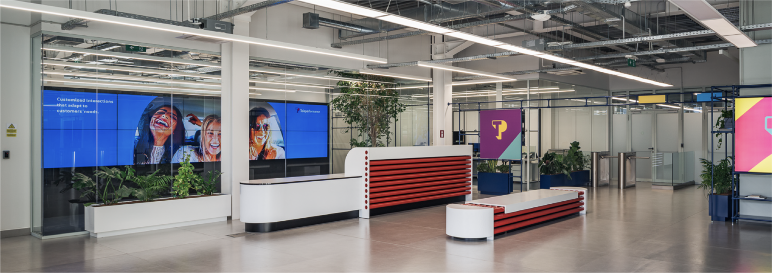 Modern TP Greece office space in Piraeus, featuring a sleek reception area with digital displays, vibrant branding, and contemporary design elements.