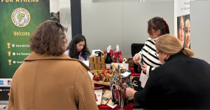 two people standing Infront of a booth at the TP Christmas bazaar 2025