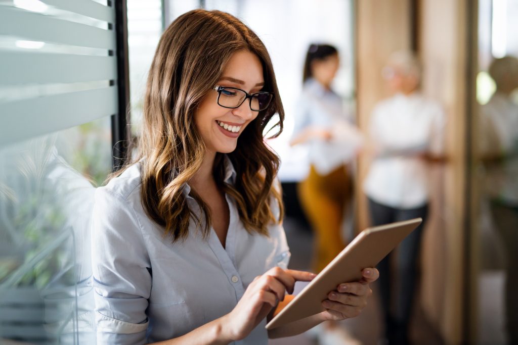 A smiling woman working on tablet